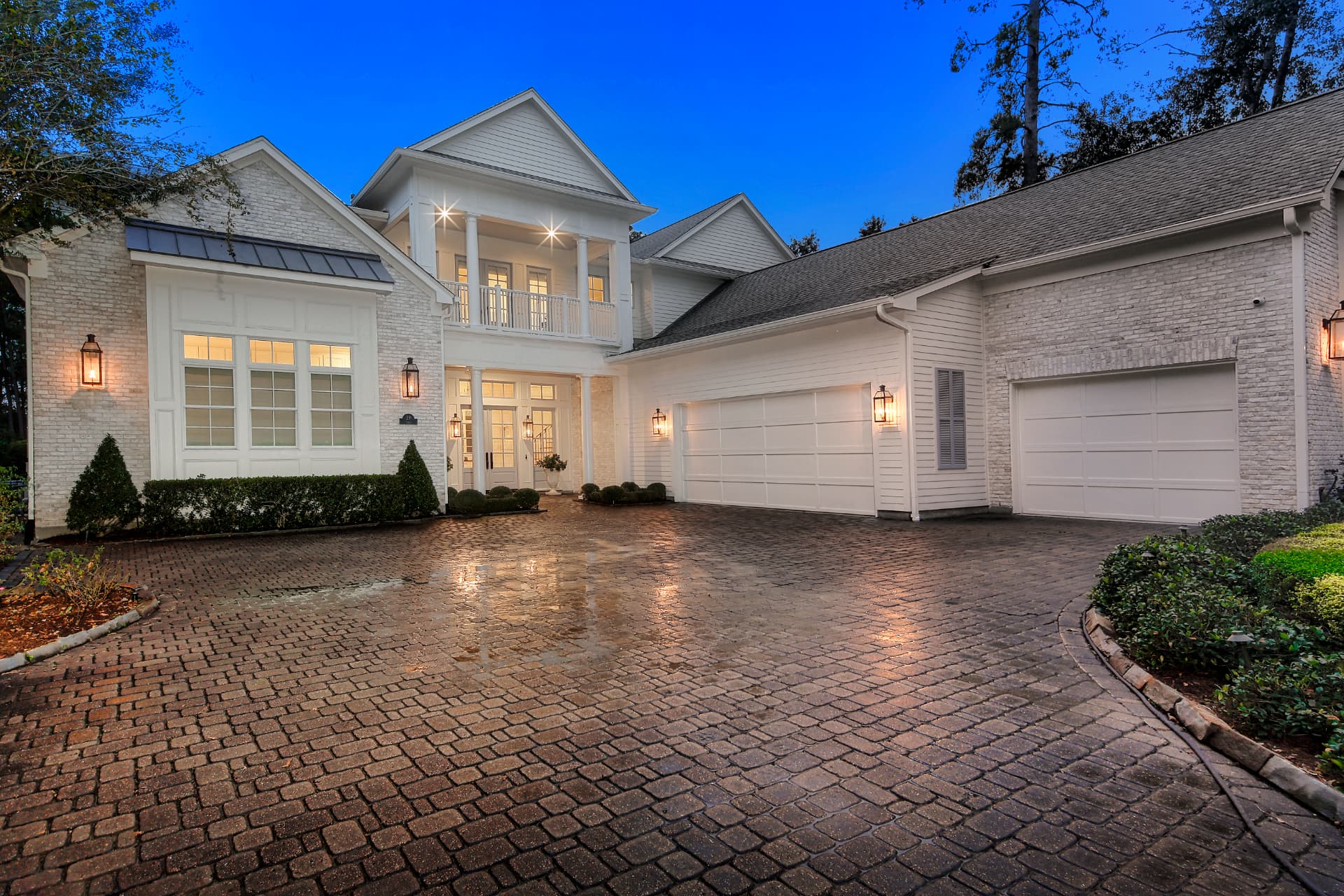 The illuminated classic façade of 29 S Doe Run Drive beneath mature trees at twilight